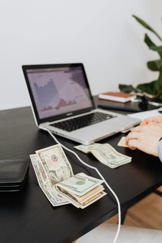 Money and laptop on desk indicating financial work or analysis. Perfect for business themes.